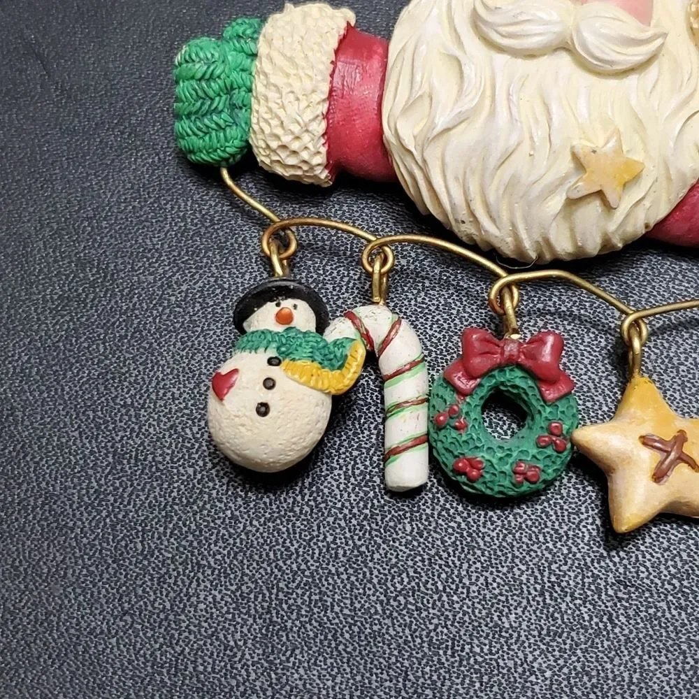 Charm holding Santa holiday brooch